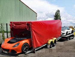 Transporteur routier pour assurer le convoyage d'un véhicule de course  